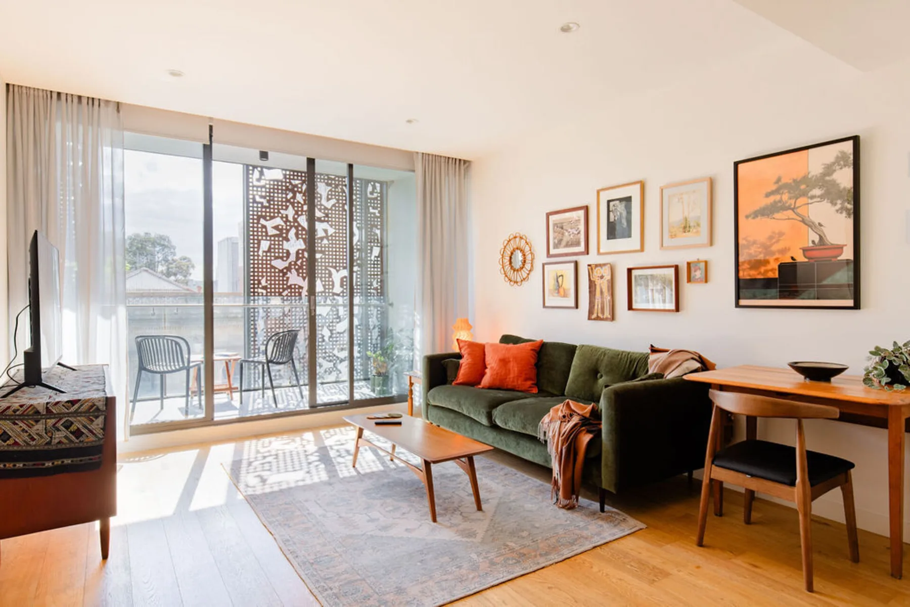 A living room with a green sofa, a coffee table, and large windows.