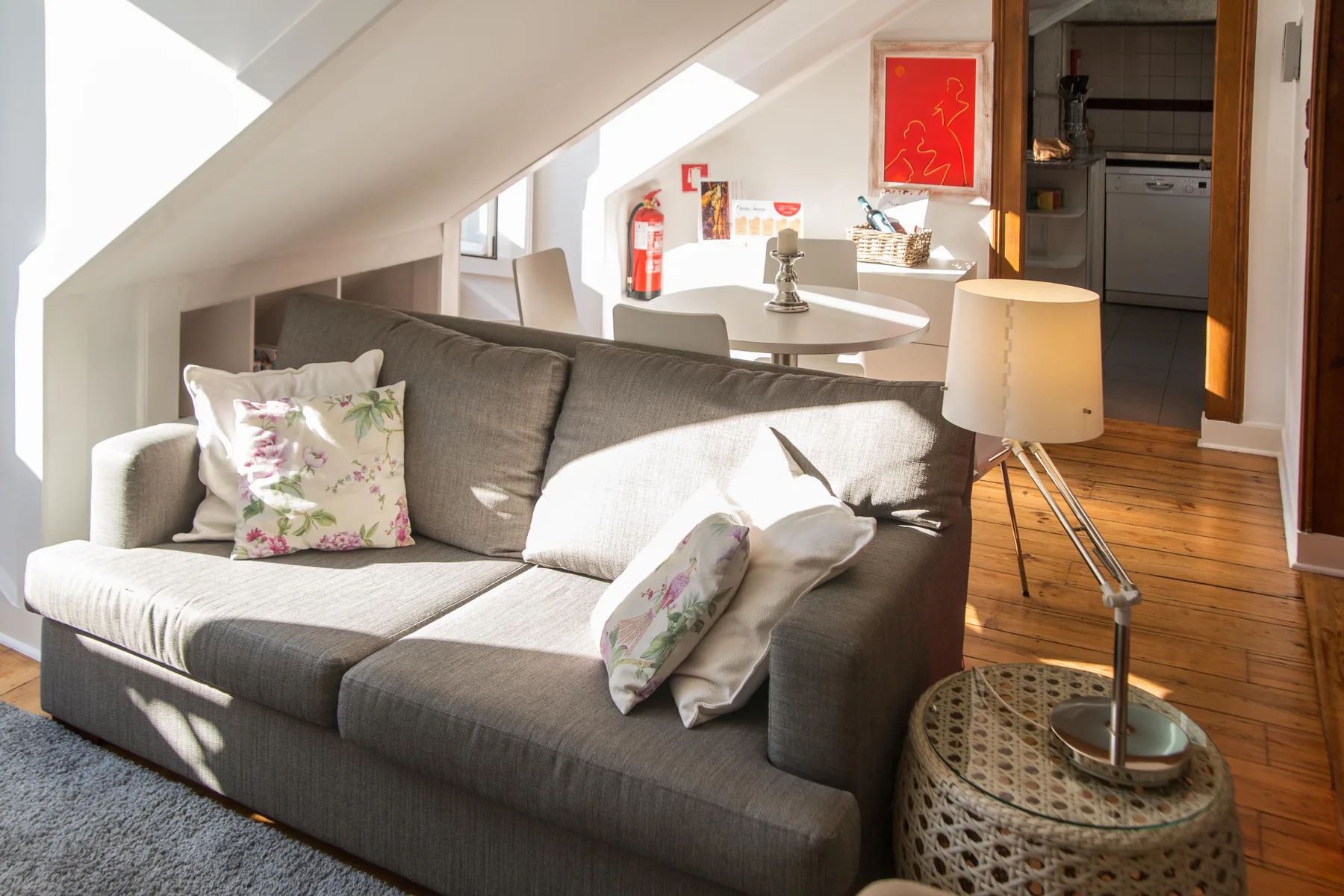 A bright living area with a gray sofa, table, and floor lamp.