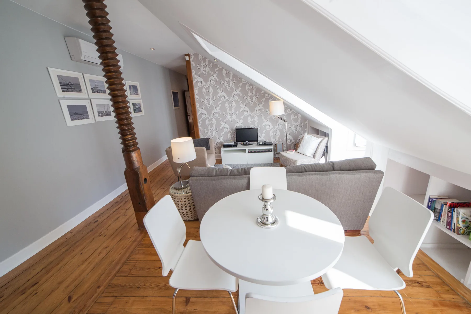 A bright living and dining area with a round table and seating.