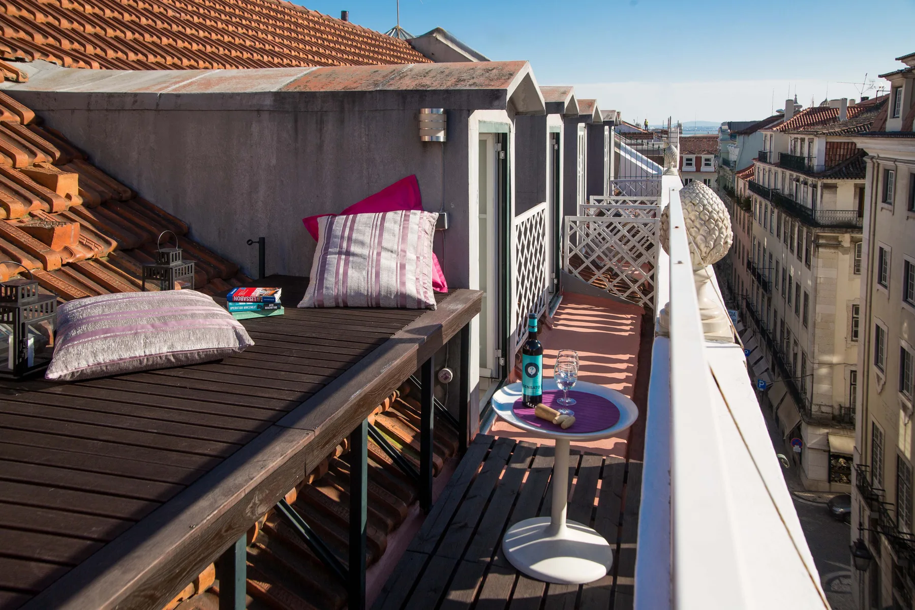 A narrow rooftop terrace with outdoor seating and a small round table.
