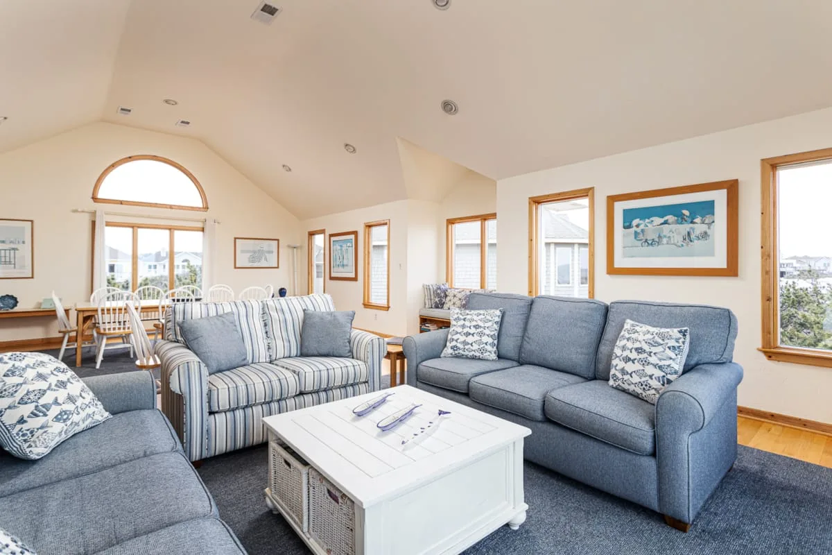 A bright living room with blue seating and a white coffee table.