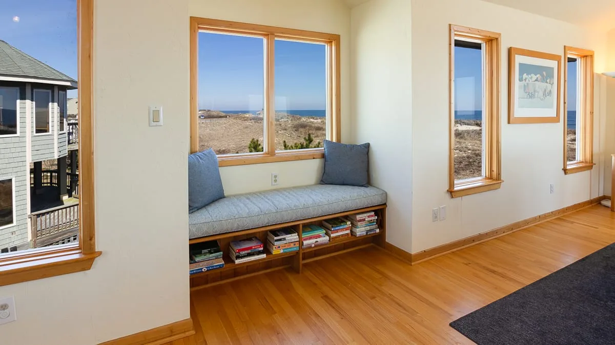 A bright sitting area has a built-in window seat overlooking the beach.