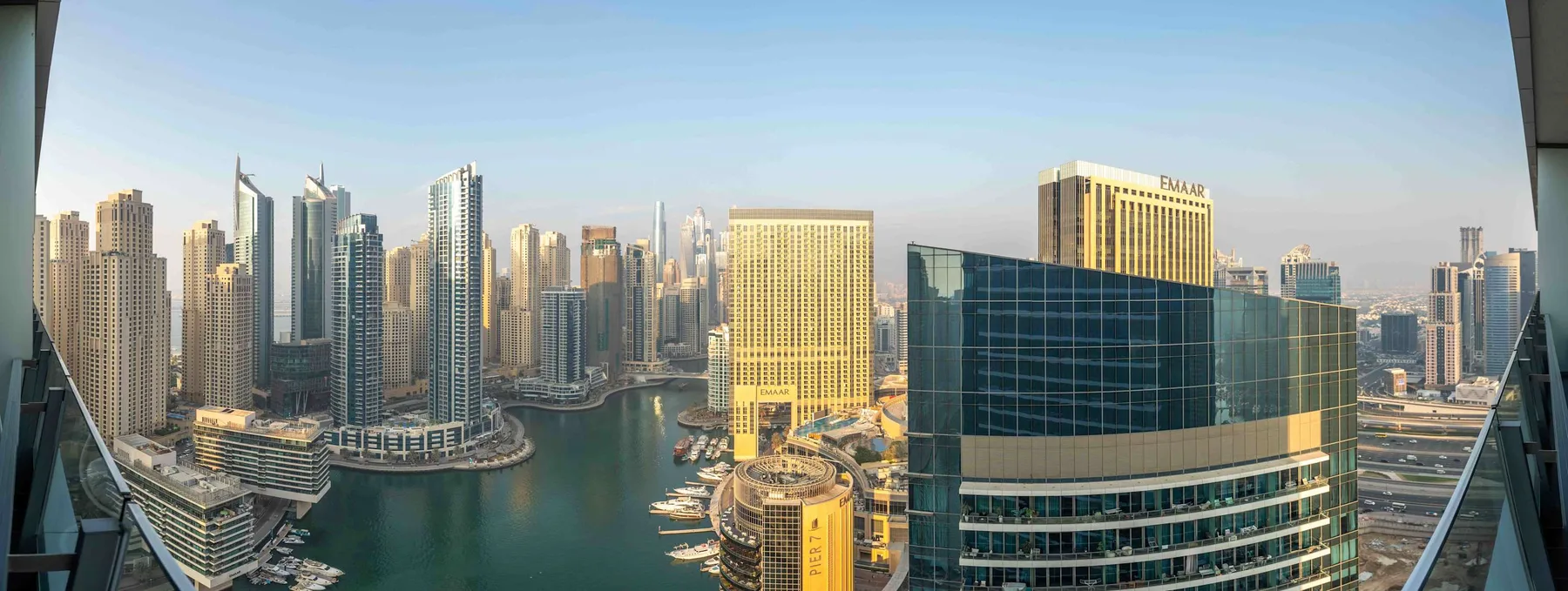 Panoramic city skyline with tall buildings surrounding a waterfront.