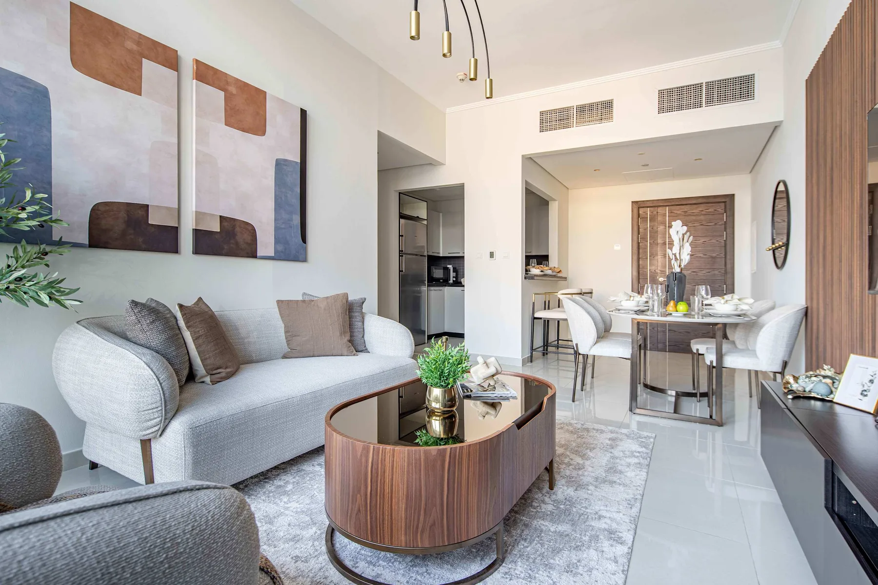 A bright living and dining area with seating, a coffee table, and a dining table.