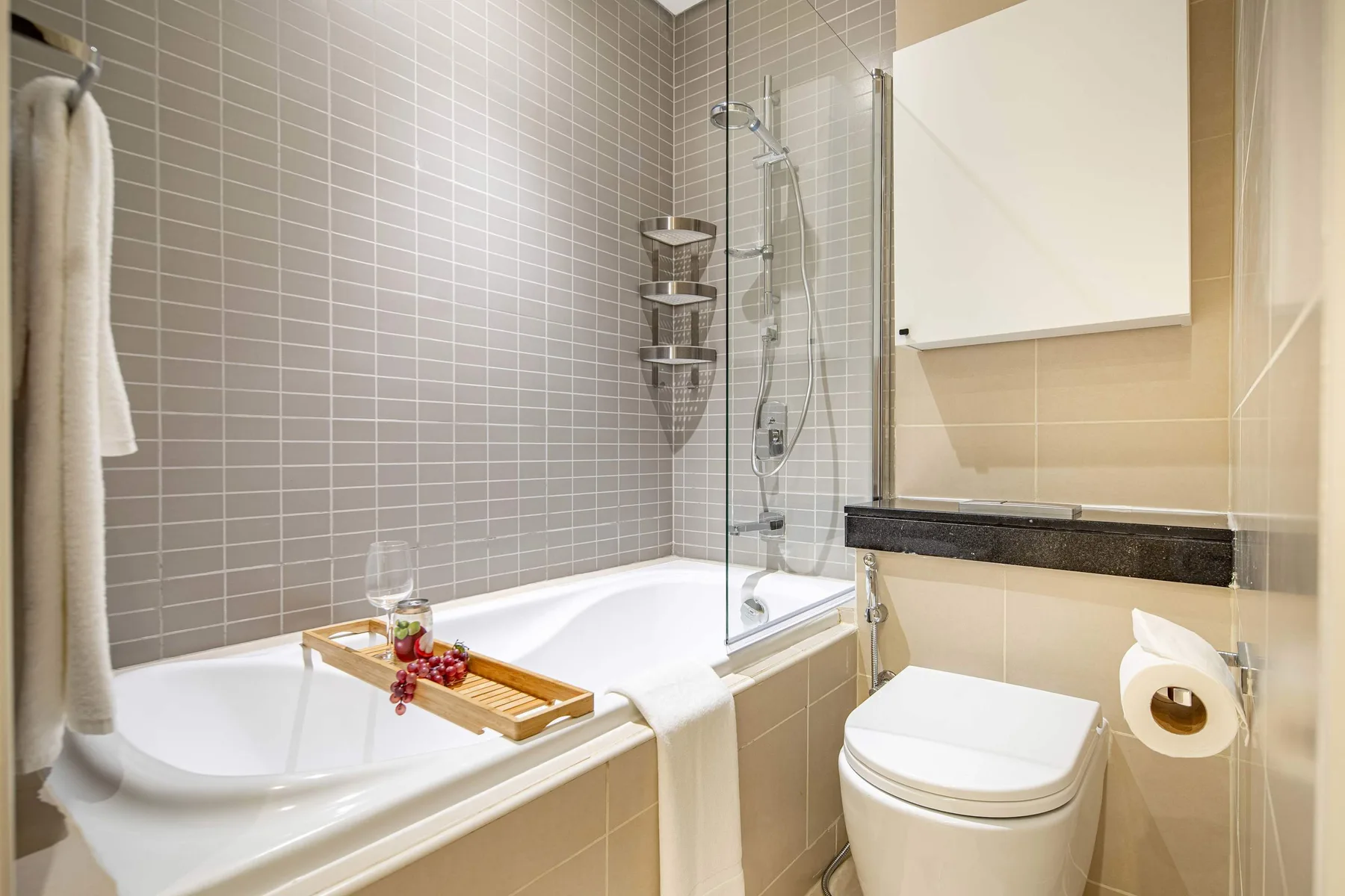 A tiled bathroom with a bathtub, shower, and toilet.