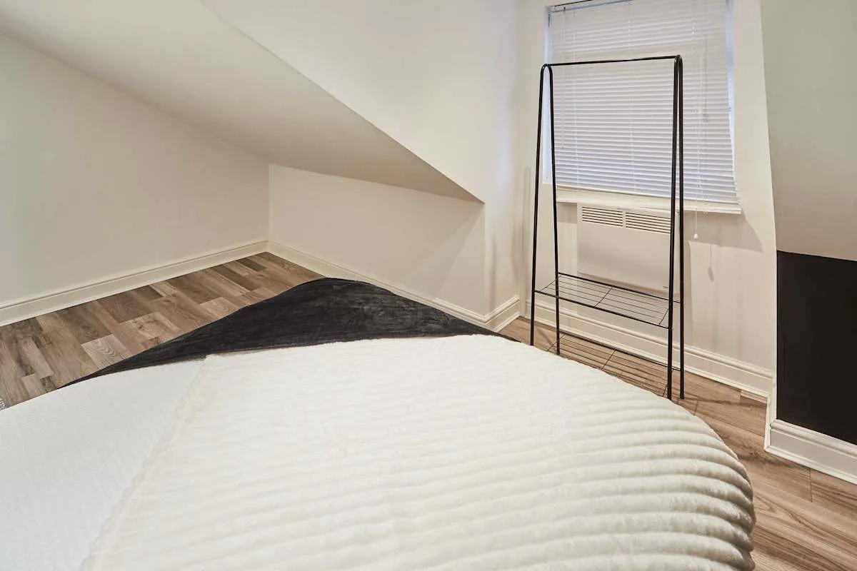 Bedroom with a bed beneath a sloped ceiling and a window.
