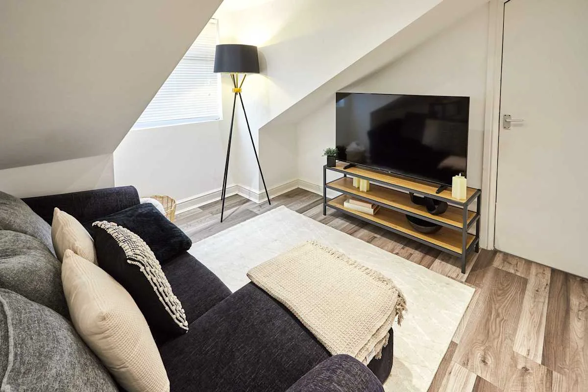 A living room with seating, a television, and a floor lamp.
