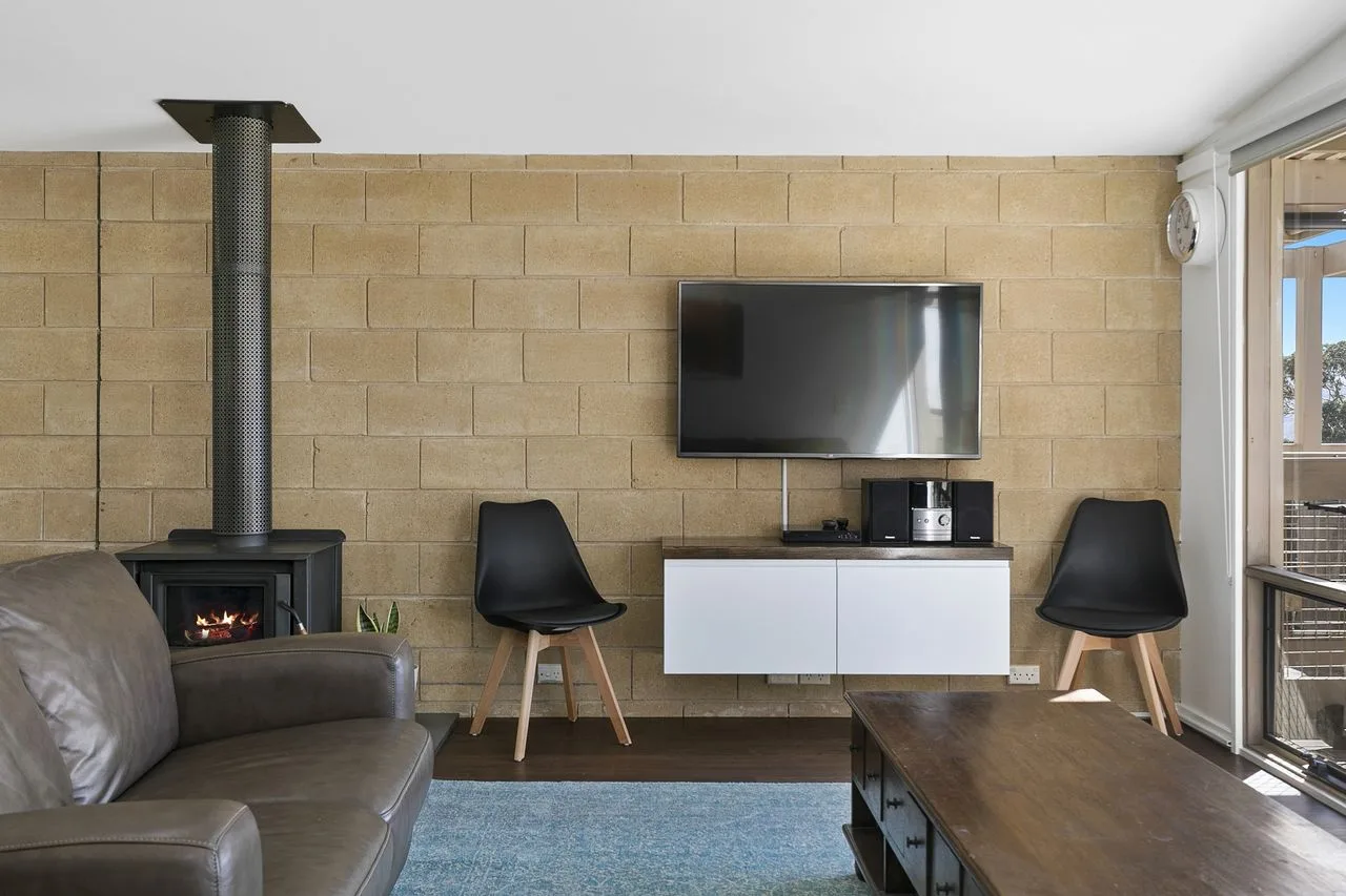 A living room with a television above a low cabinet.