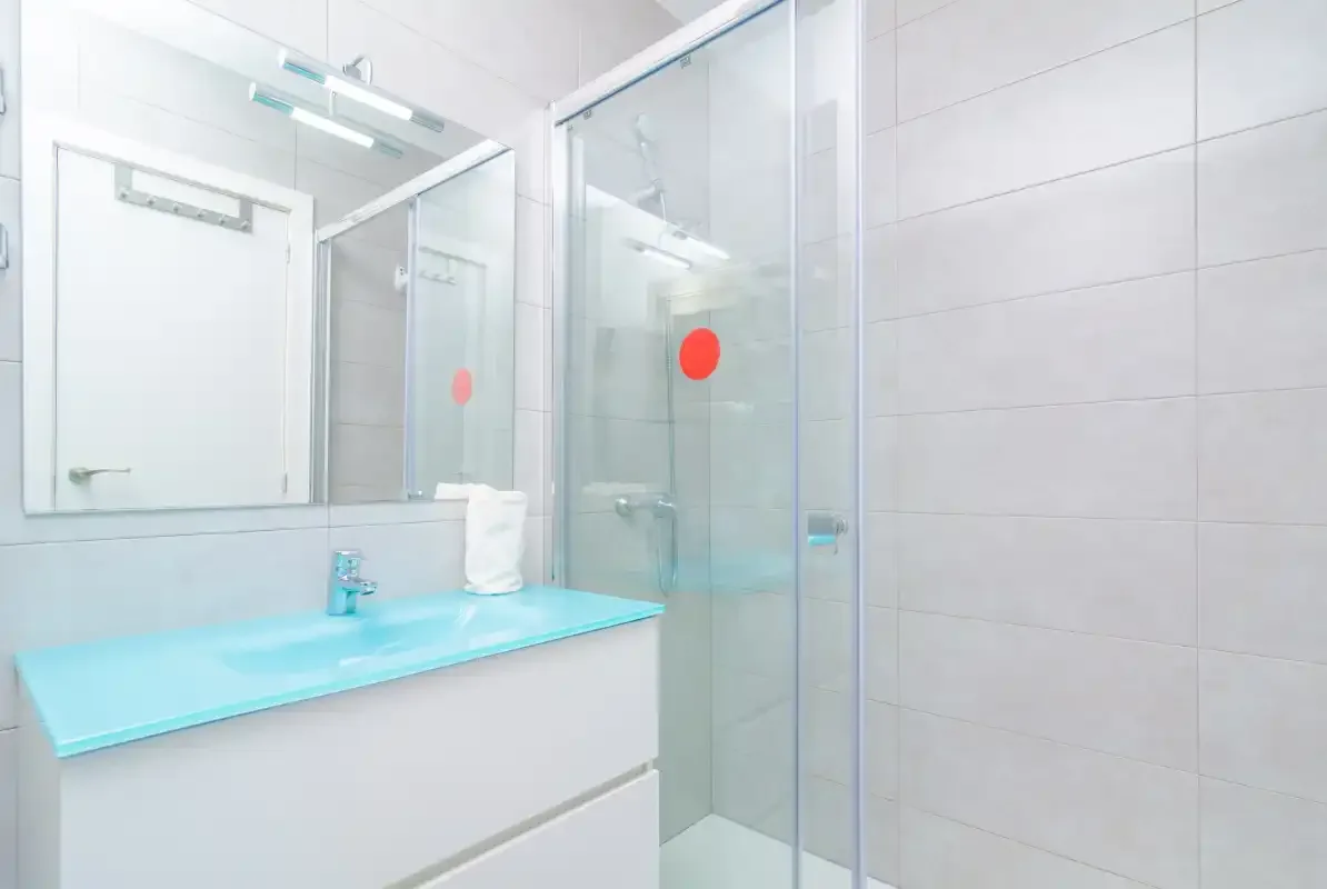 A tiled bathroom with a sink and glass shower.