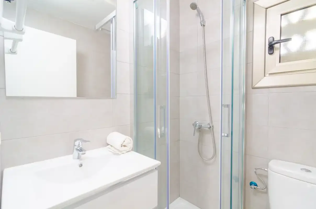 A bright bathroom with a sink and shower.