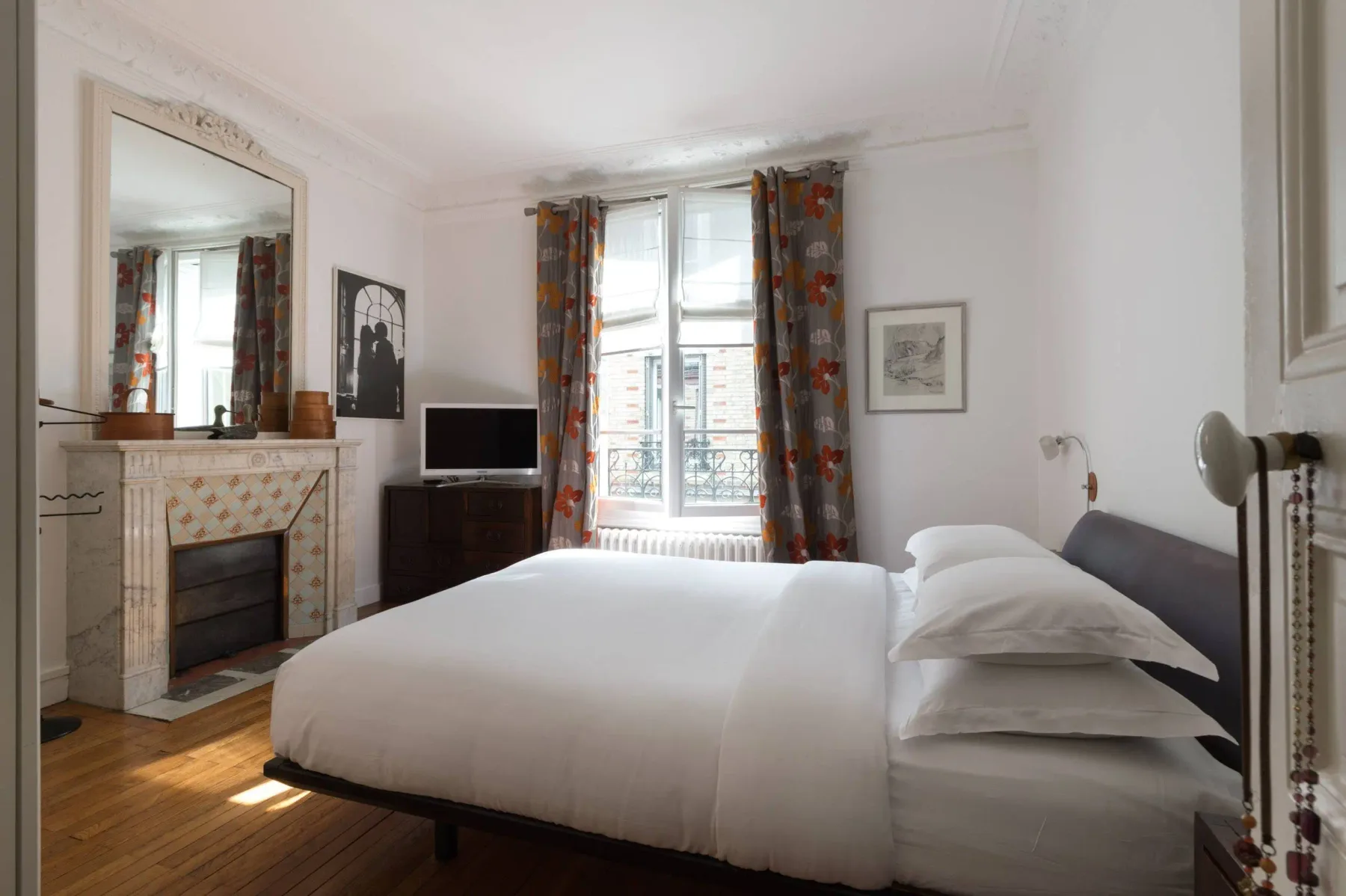 Un dormitorio con una cama grande junto a una ventana luminosa.