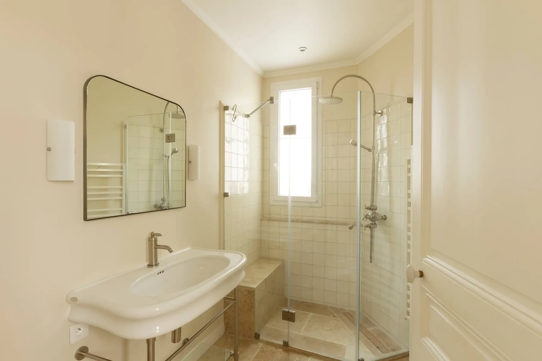 Un baño luminoso con lavabo y ducha de vidrio.