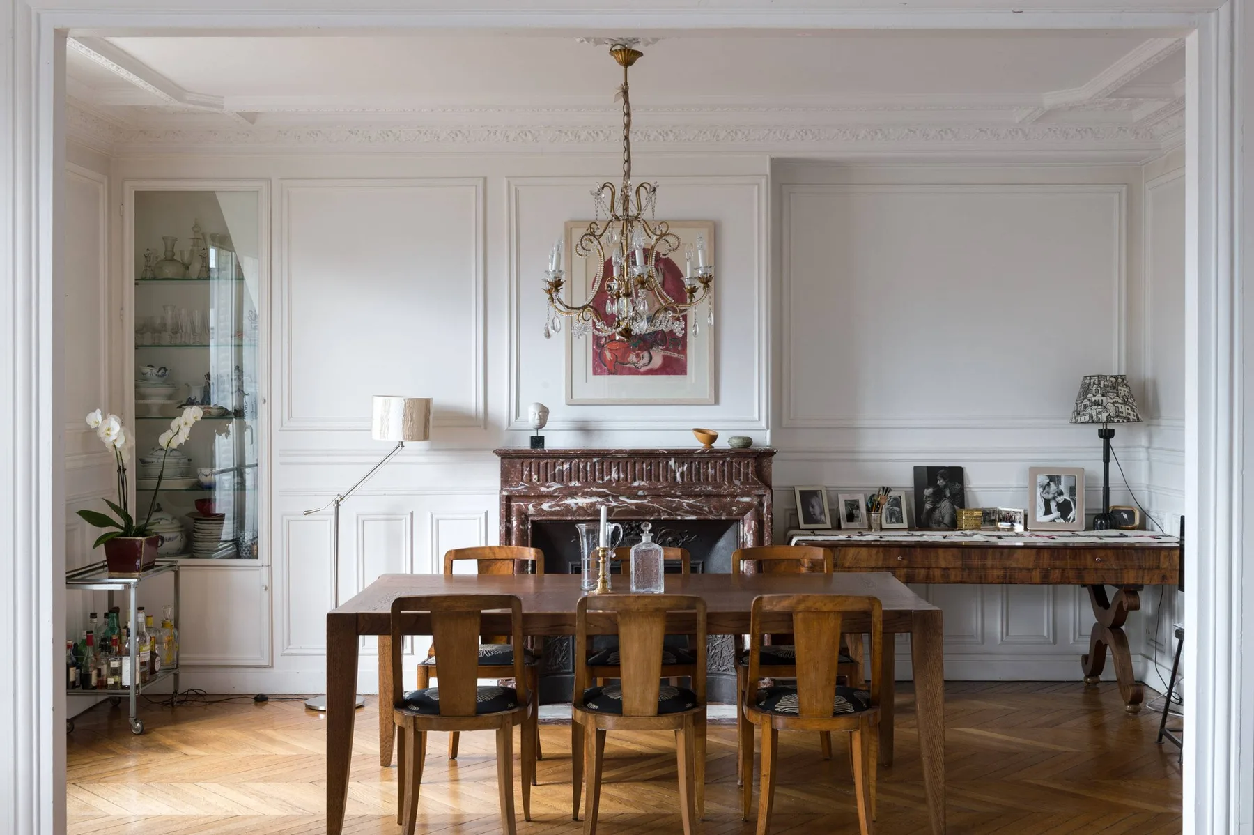 Un comedor formal con una mesa de madera y sillas frente a una chimenea.