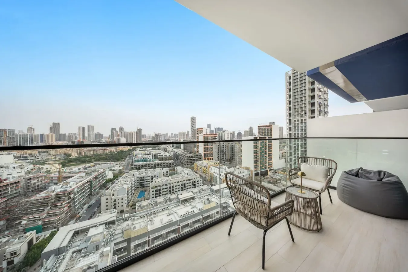 Un balcón con asientos ofrece vistas de un denso horizonte urbano.