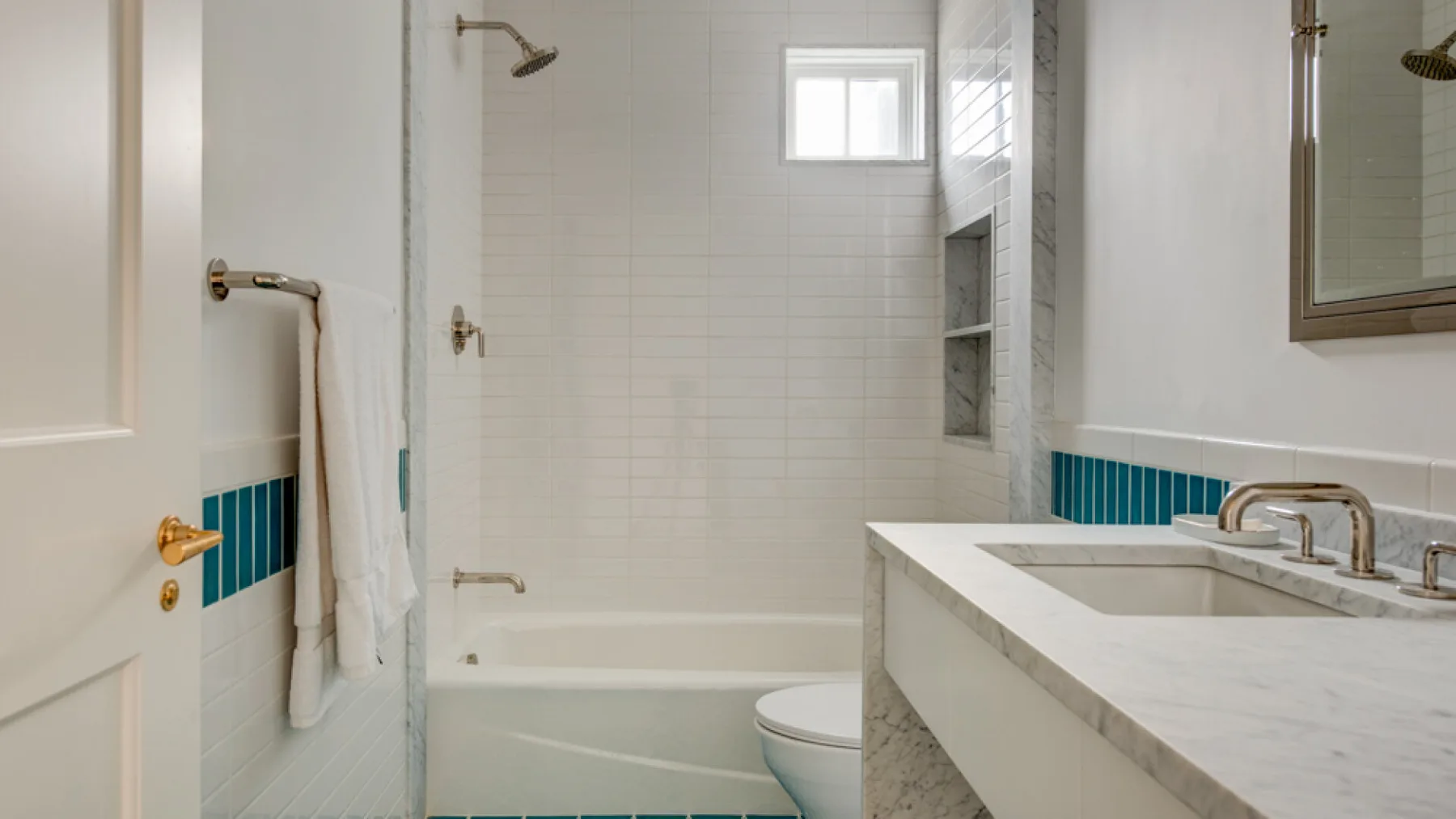Baño con azulejos, bañera, ducha, inodoro y lavabo con mueble.