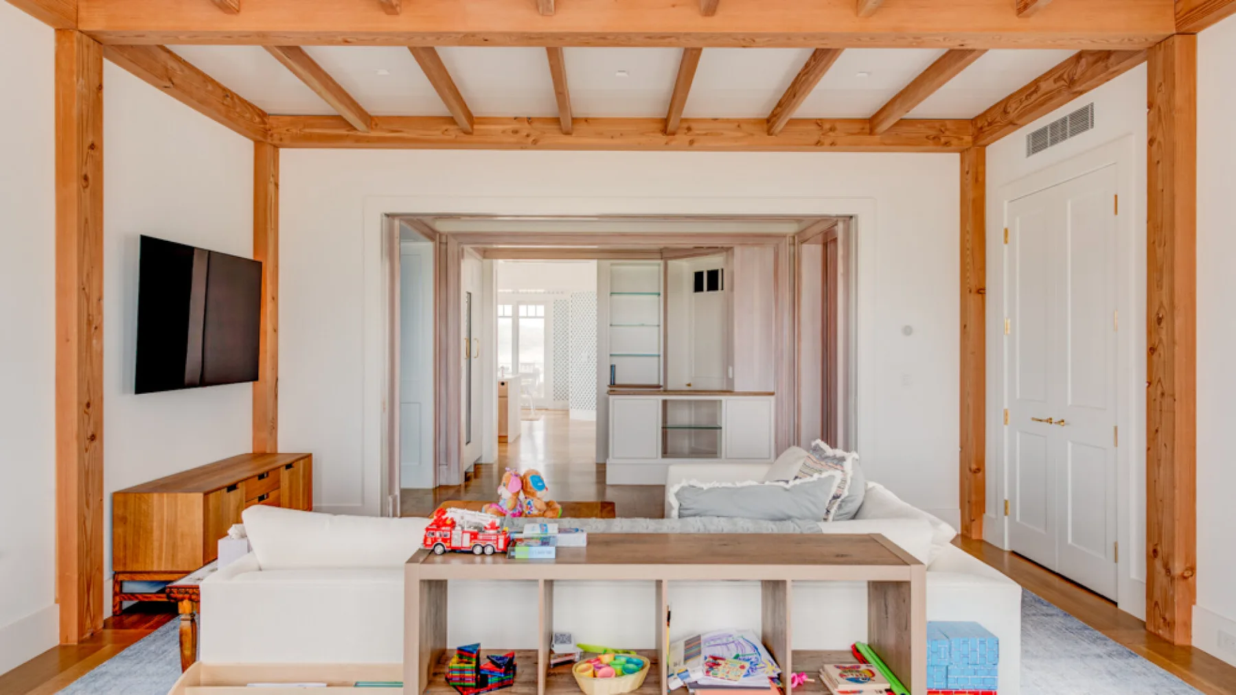 Una sala de estar luminosa con una zona de asientos y estantería abierta.