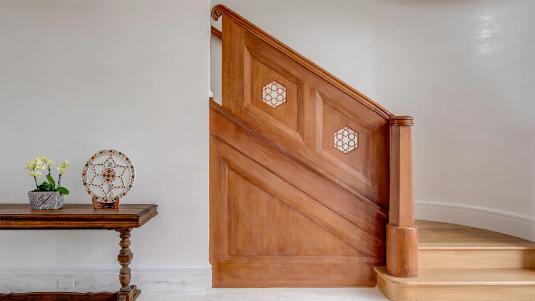 Una escalera interior con paneles de madera pulida y detalles decorativos.