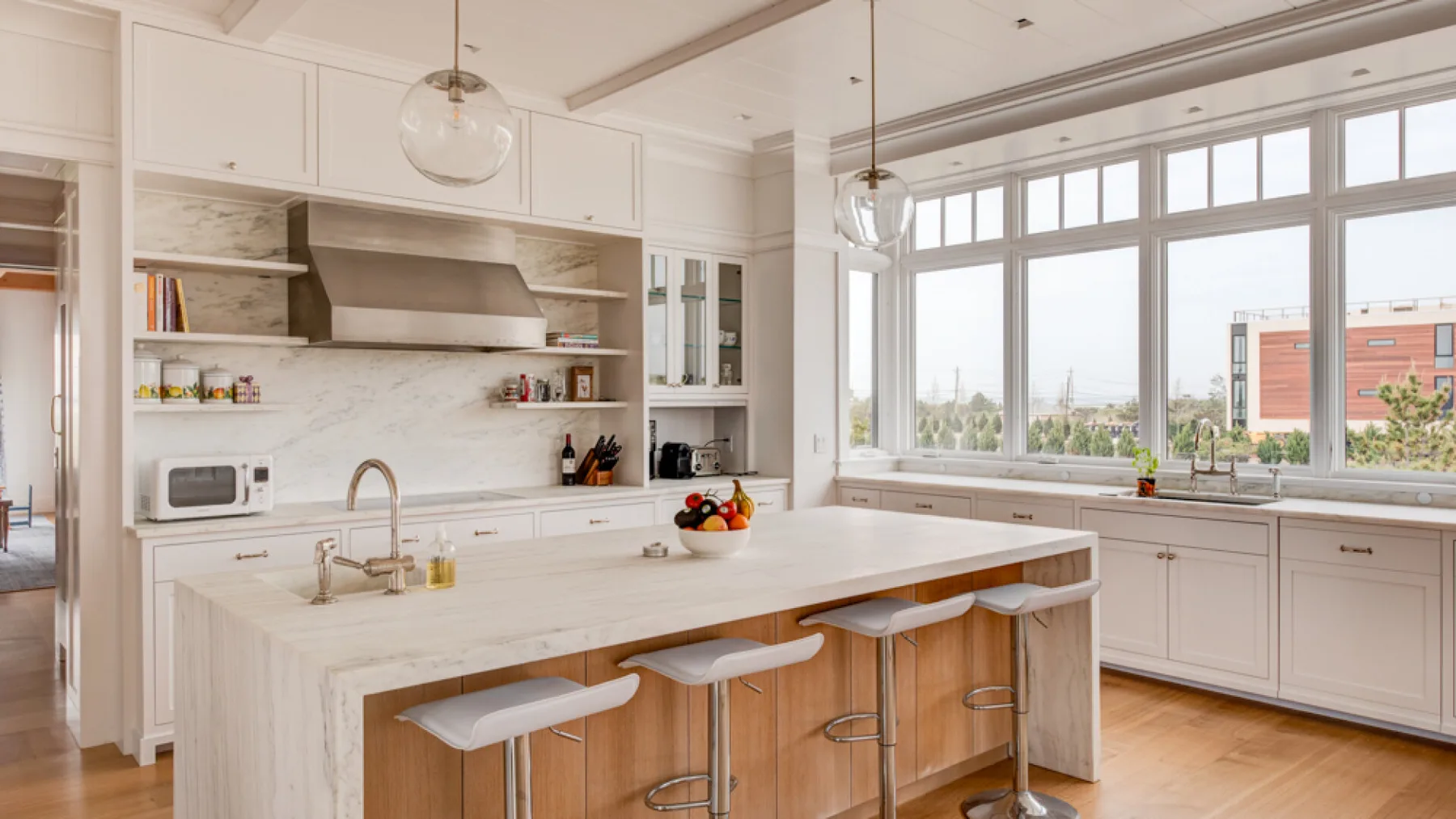 Una cocina luminosa con una isla grande y amplias ventanas.