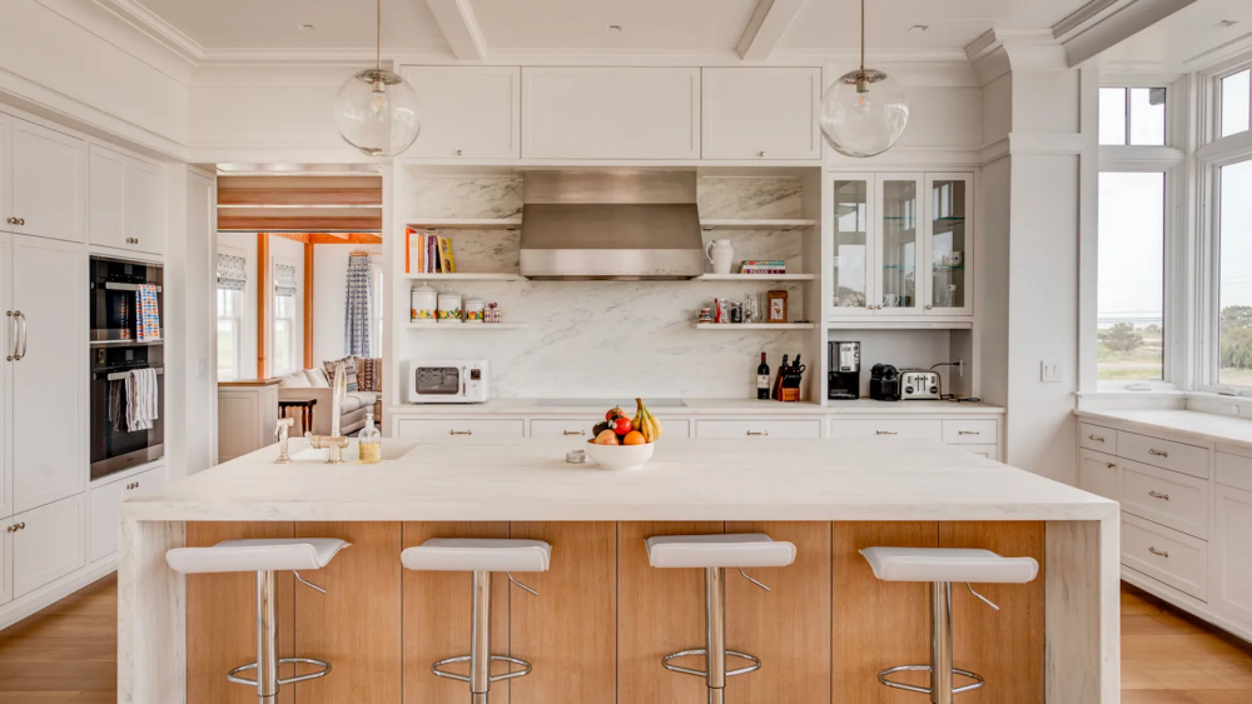 Una cocina luminosa con una isla grande y gabinetes de madera clara.