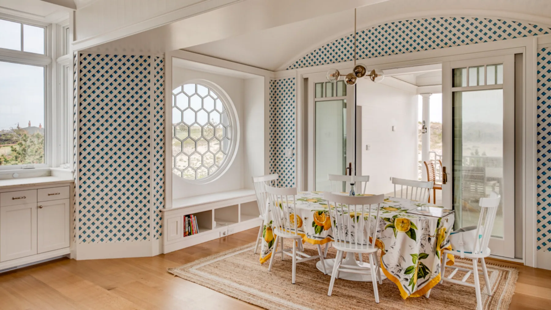 Un comedor luminoso con un mantel floral y paneles de pared estampados.