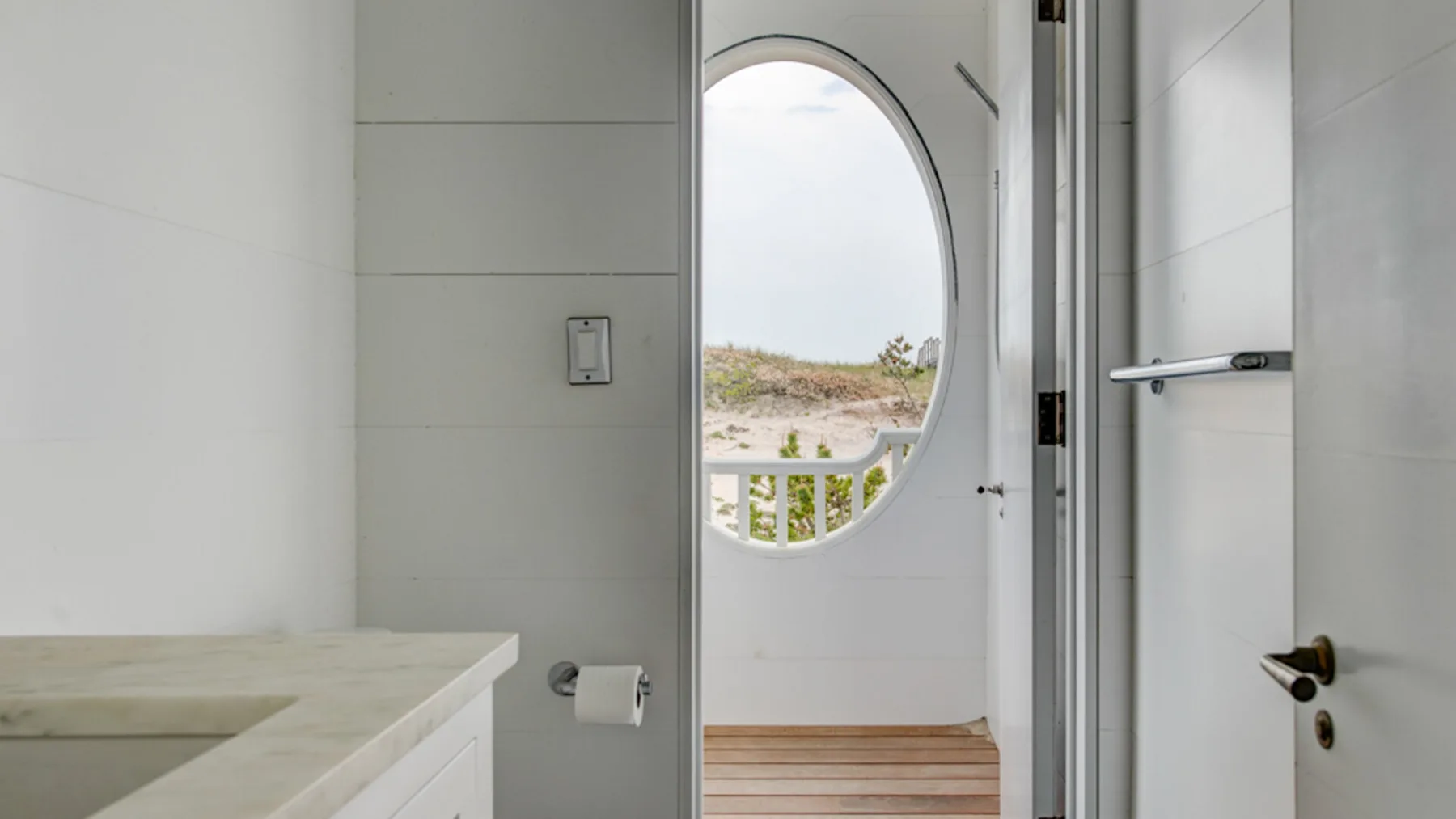 Un baño luminoso con una puerta que da a un balcón.
