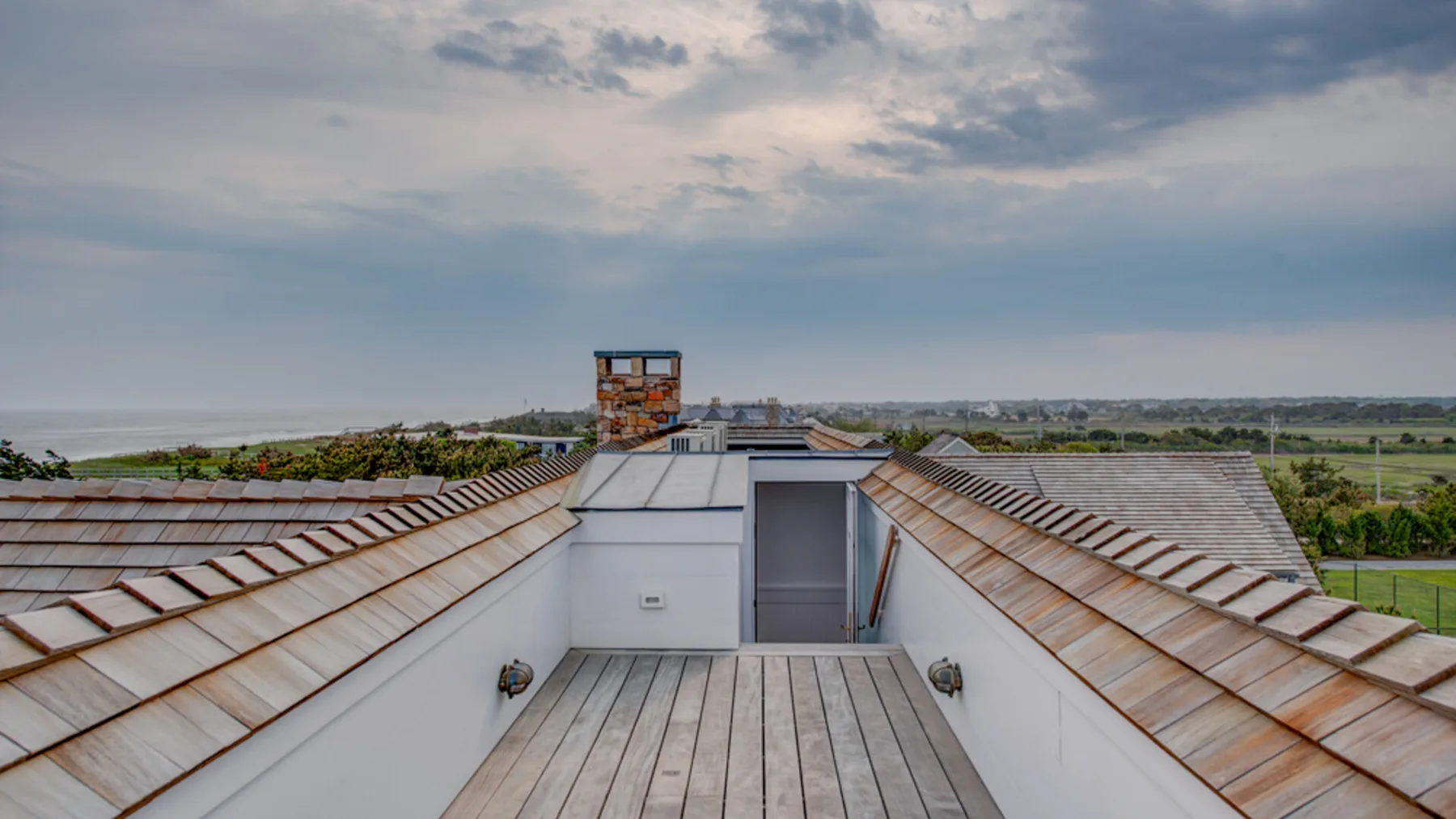 Una terraza en la azotea ofrece vistas de un amplio paisaje bajo un cielo nublado.