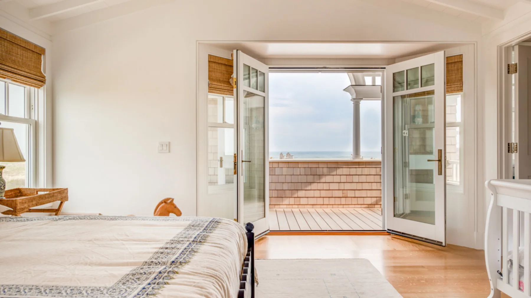 Un dormitorio luminoso se abre a un balcón con vistas al mar.