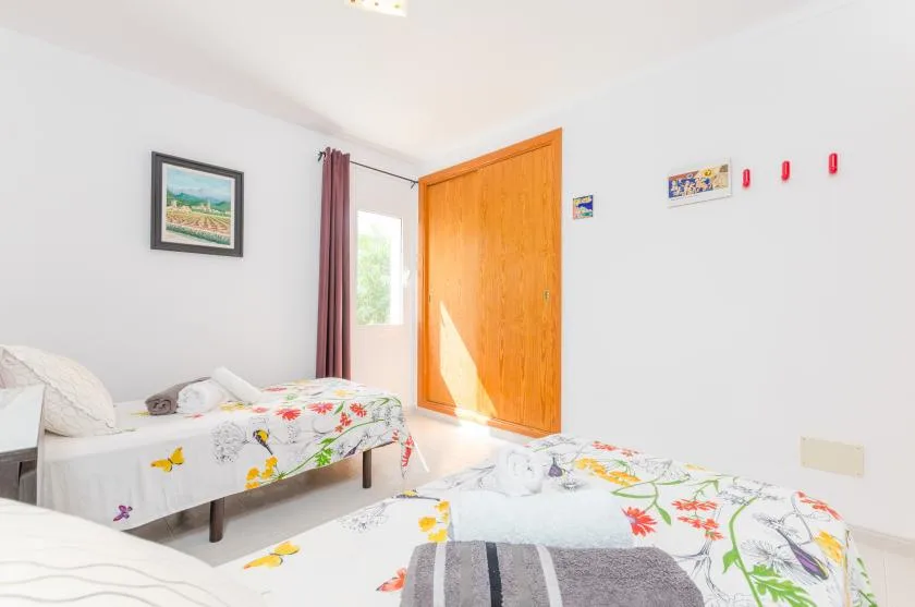 A bedroom with two beds covered in colorful floral bedding.