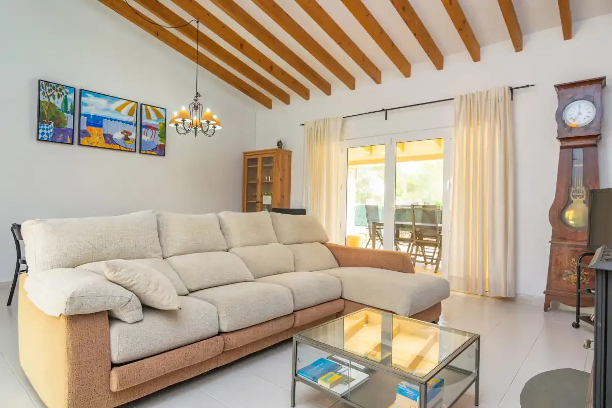 A living room with a sectional seating area and glass coffee table.