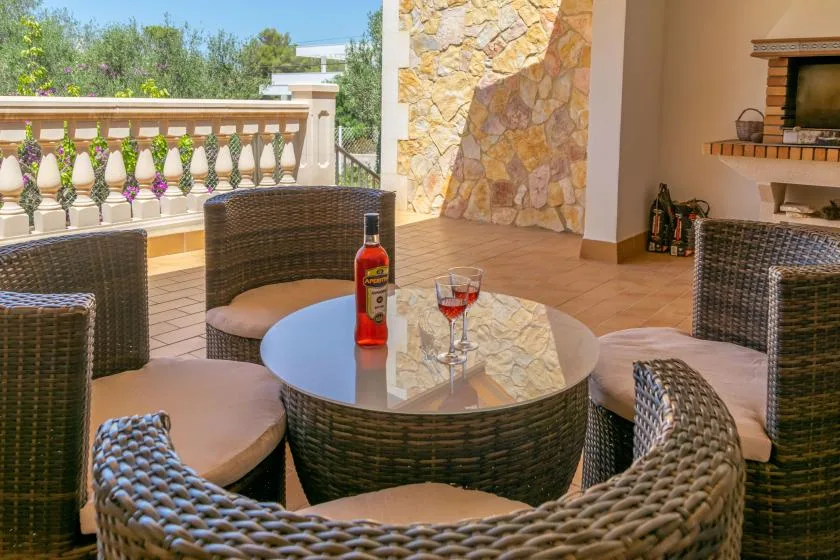 An outdoor patio seating area with a round table beside a stone wall.