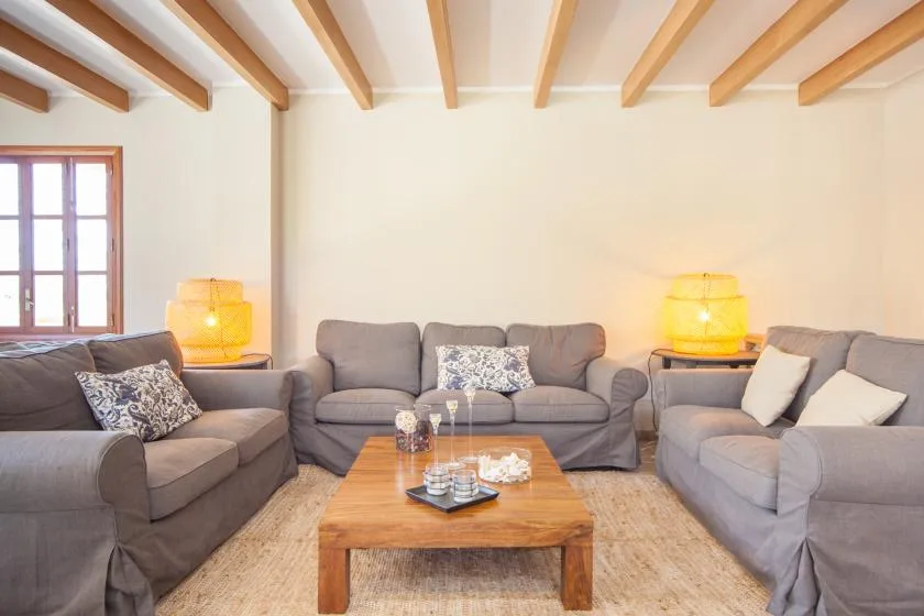 A living room with seating arranged around a wooden coffee table.