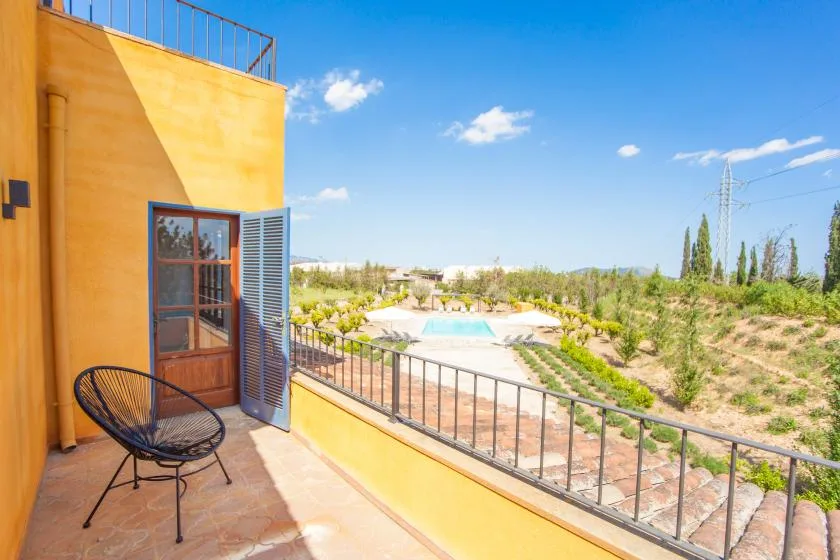A sunny balcony overlooks a landscaped pool area and surrounding greenery.