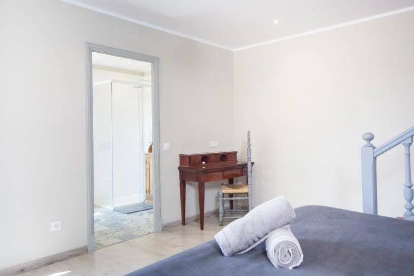 A bedroom with a bed and an open doorway to a bathroom.