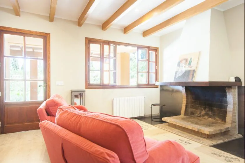 A bright living room with coral seating and a large fireplace.