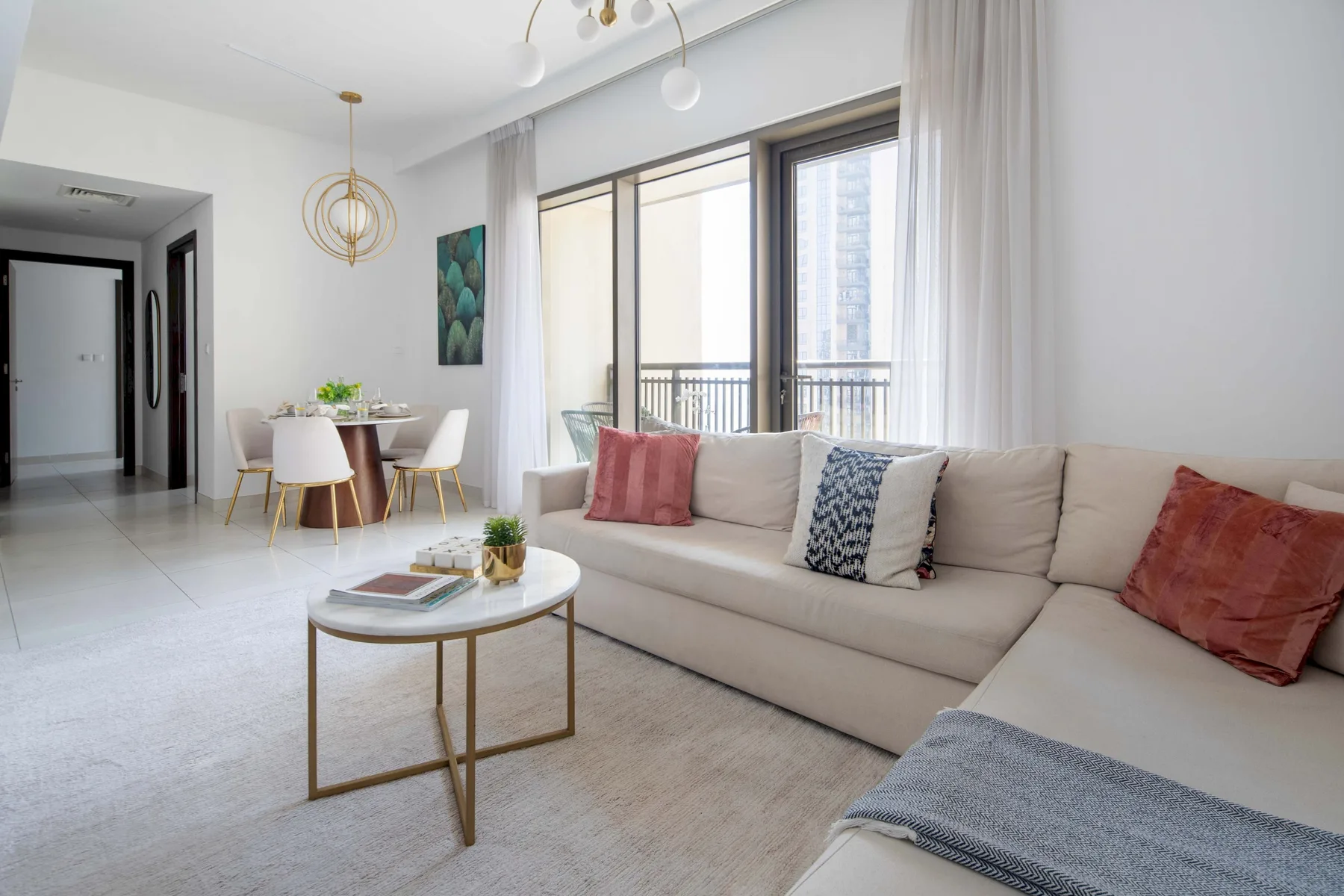 Una sala luminosa con una zona de asientos y una mesa de comedor junto a las ventanas.