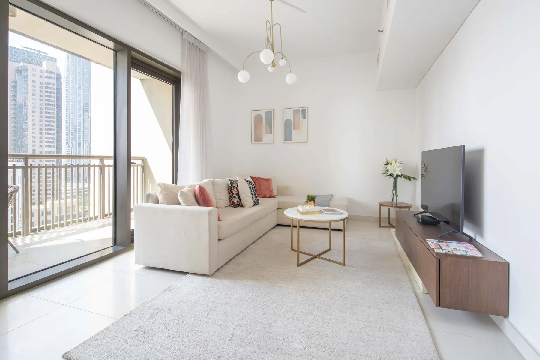 Una sala de estar luminosa con sofá, mesa de centro y grandes ventanas.