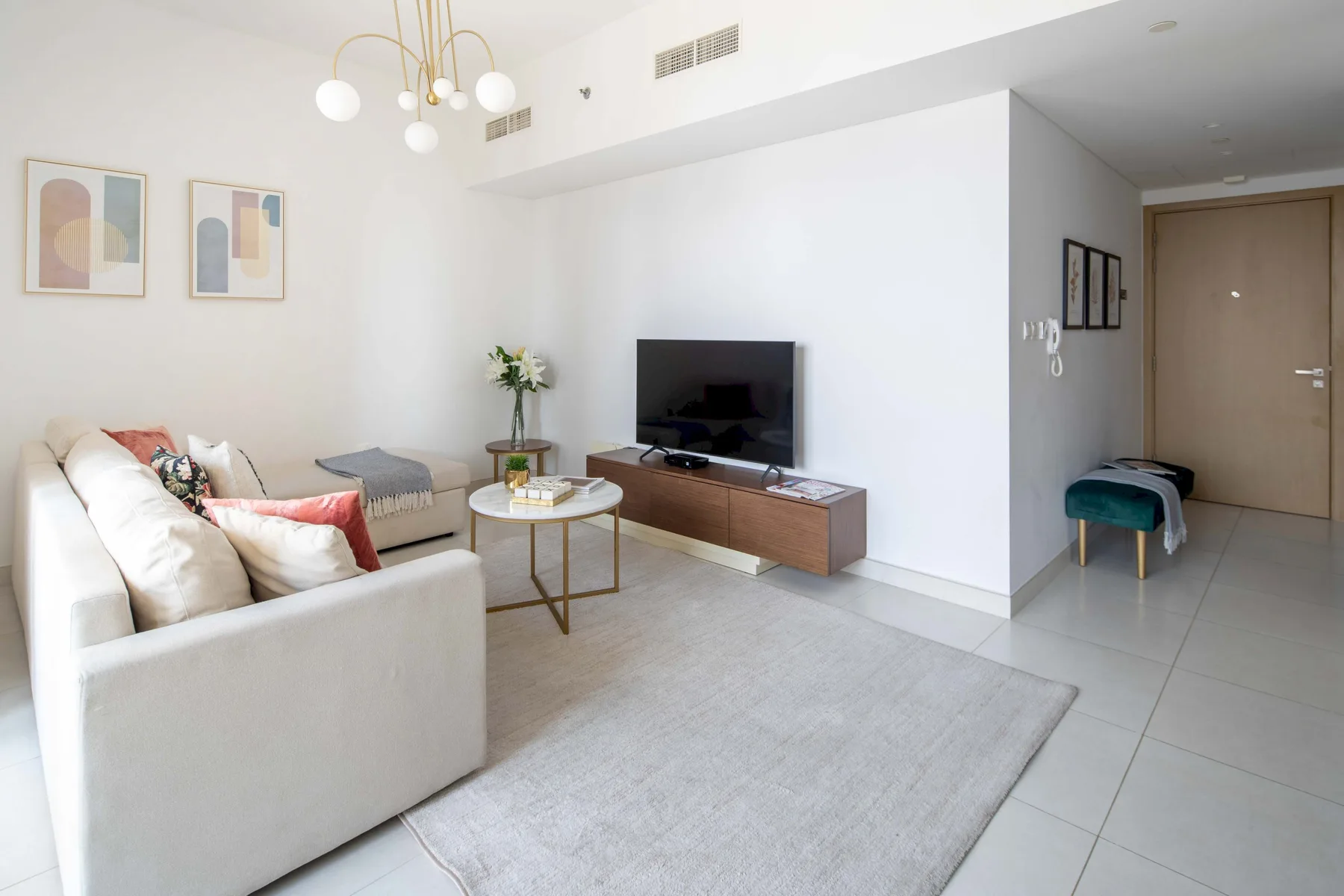 Una sala de estar luminosa con sofá, mesa de centro y televisor.