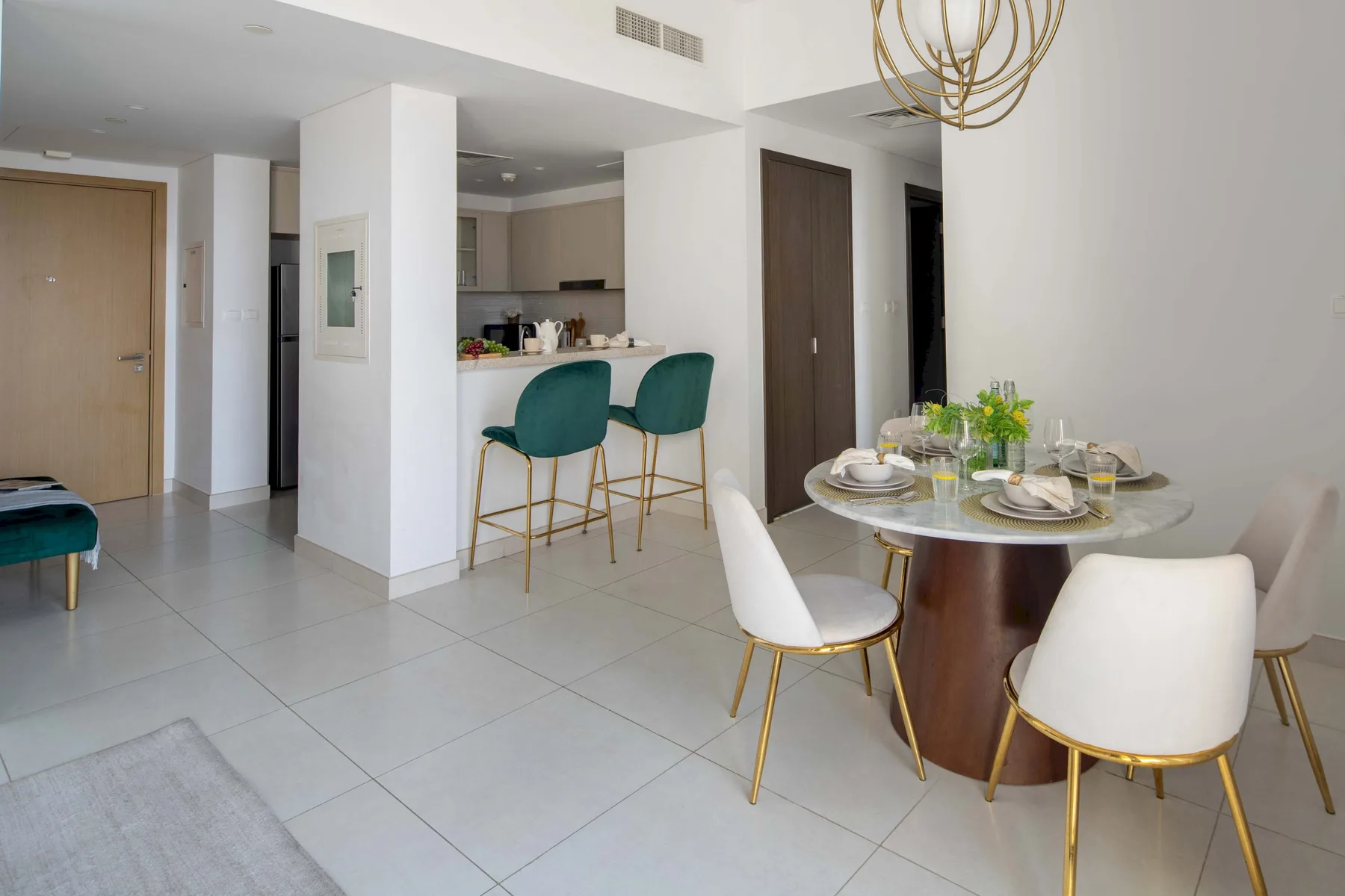 Comedor abierto con una mesa puesta y una barra de cocina con asientos.