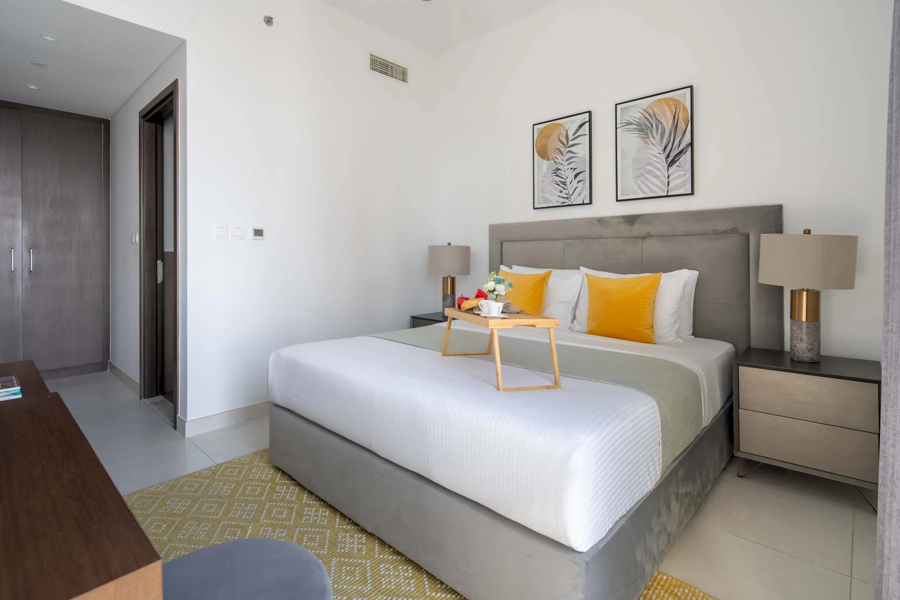 Un dormitorio con una cama bien hecha y cuadros a juego sobre el cabecero.