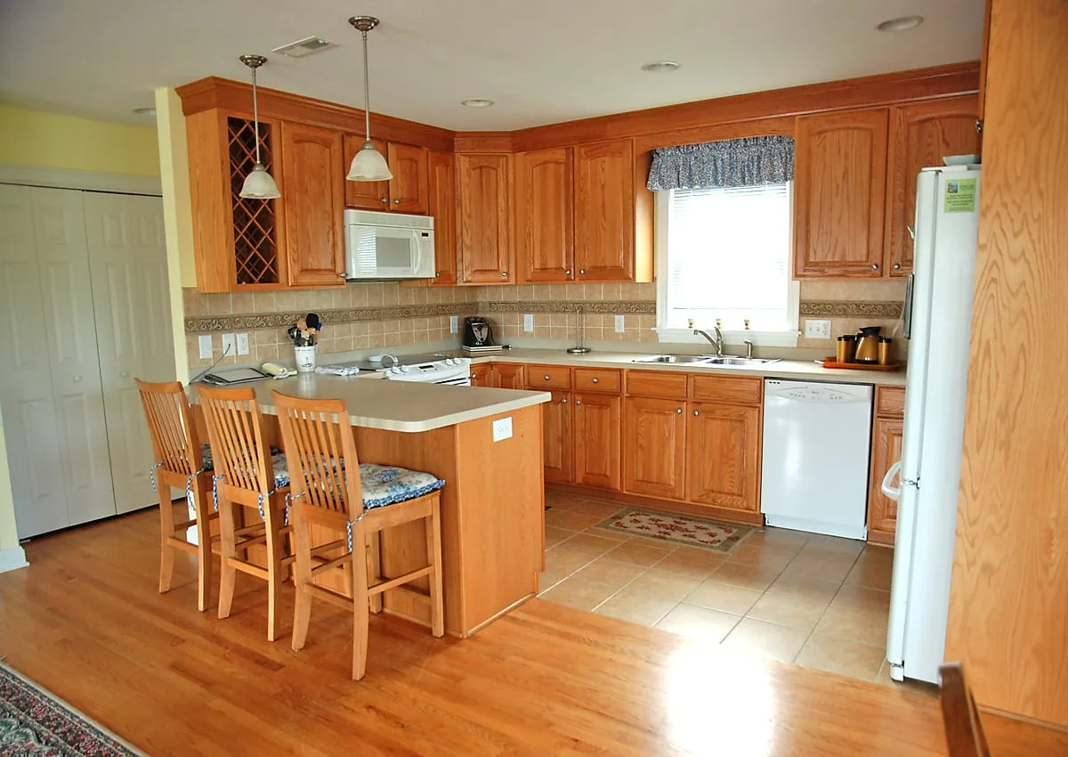 A spacious kitchen with wooden cabinets, a central island, and a window above the sink.