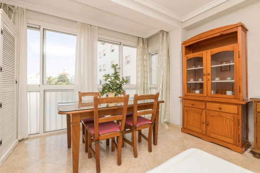 A dining area with a wooden table, chairs, and a glass-front cabinet.