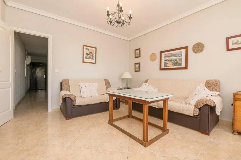 A living room with two sofas and a coffee table beneath framed wall art.