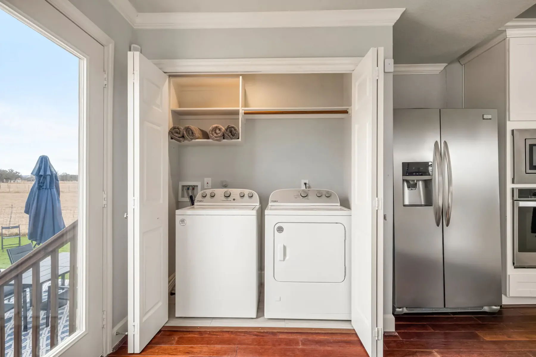 A laundry area with a washer and dryer beside a stainless steel refrigerator.