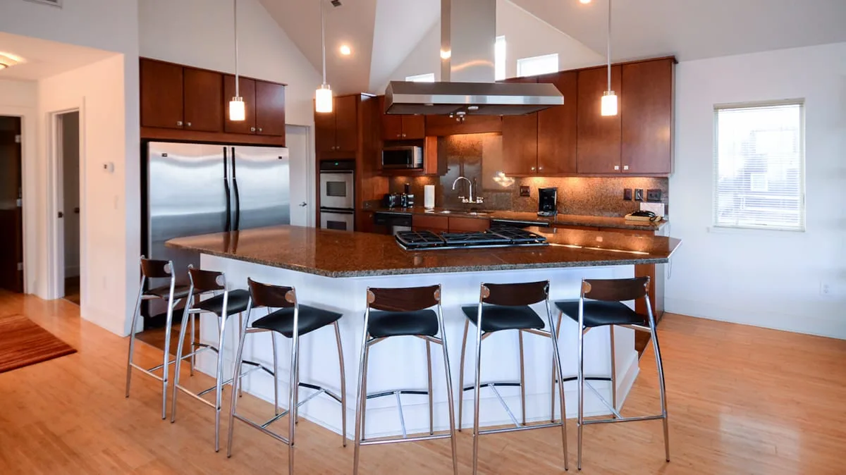 Una cocina moderna con una gran isla y asientos de barra.