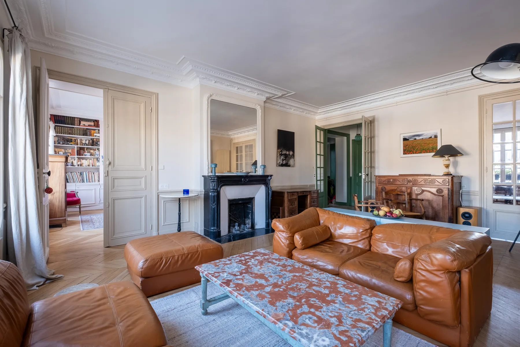 A living room with leather seating, a fireplace, and a patterned coffee table.