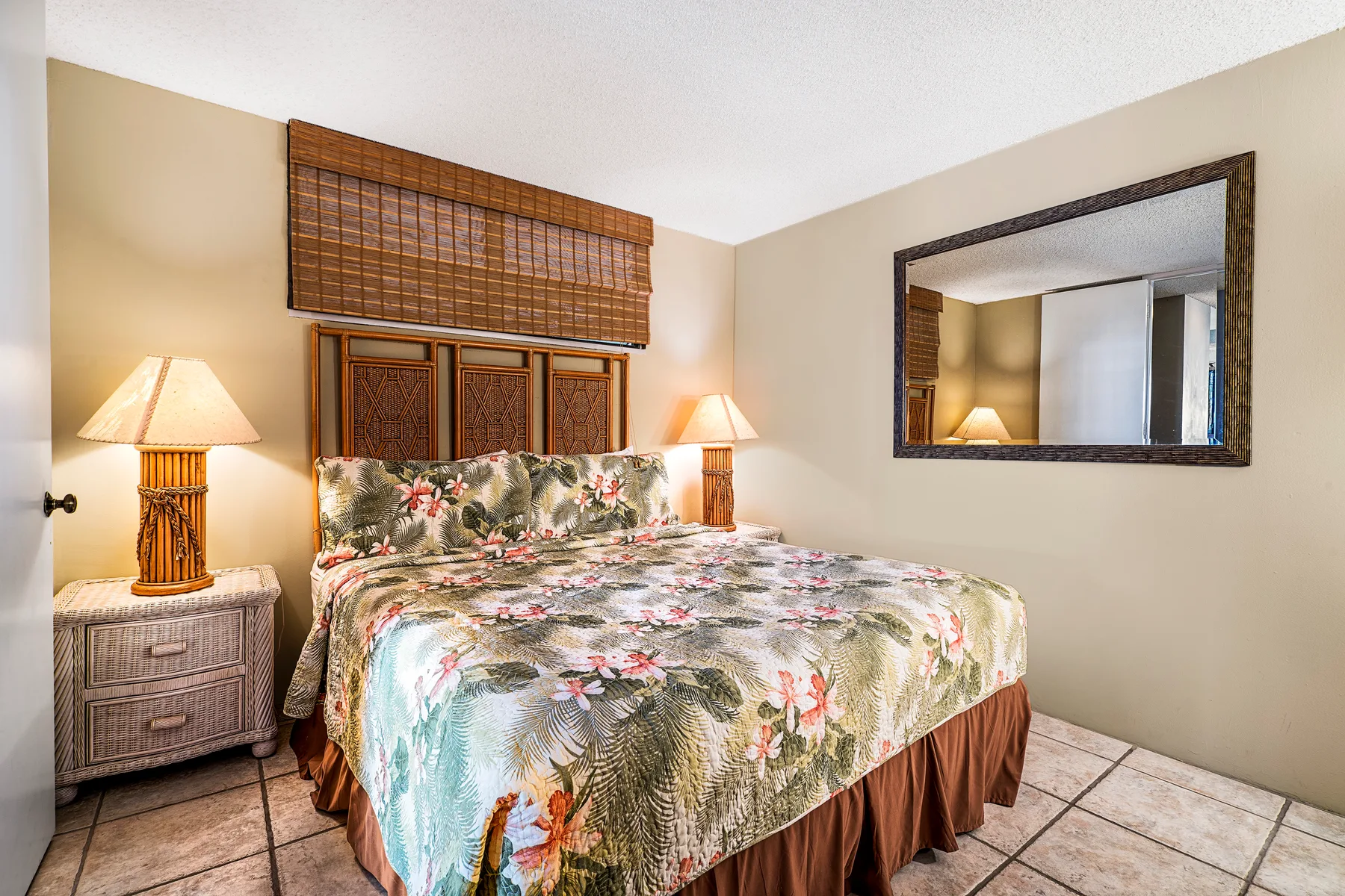 Un dormitorio con una colcha floral y lámparas junto a la cama.