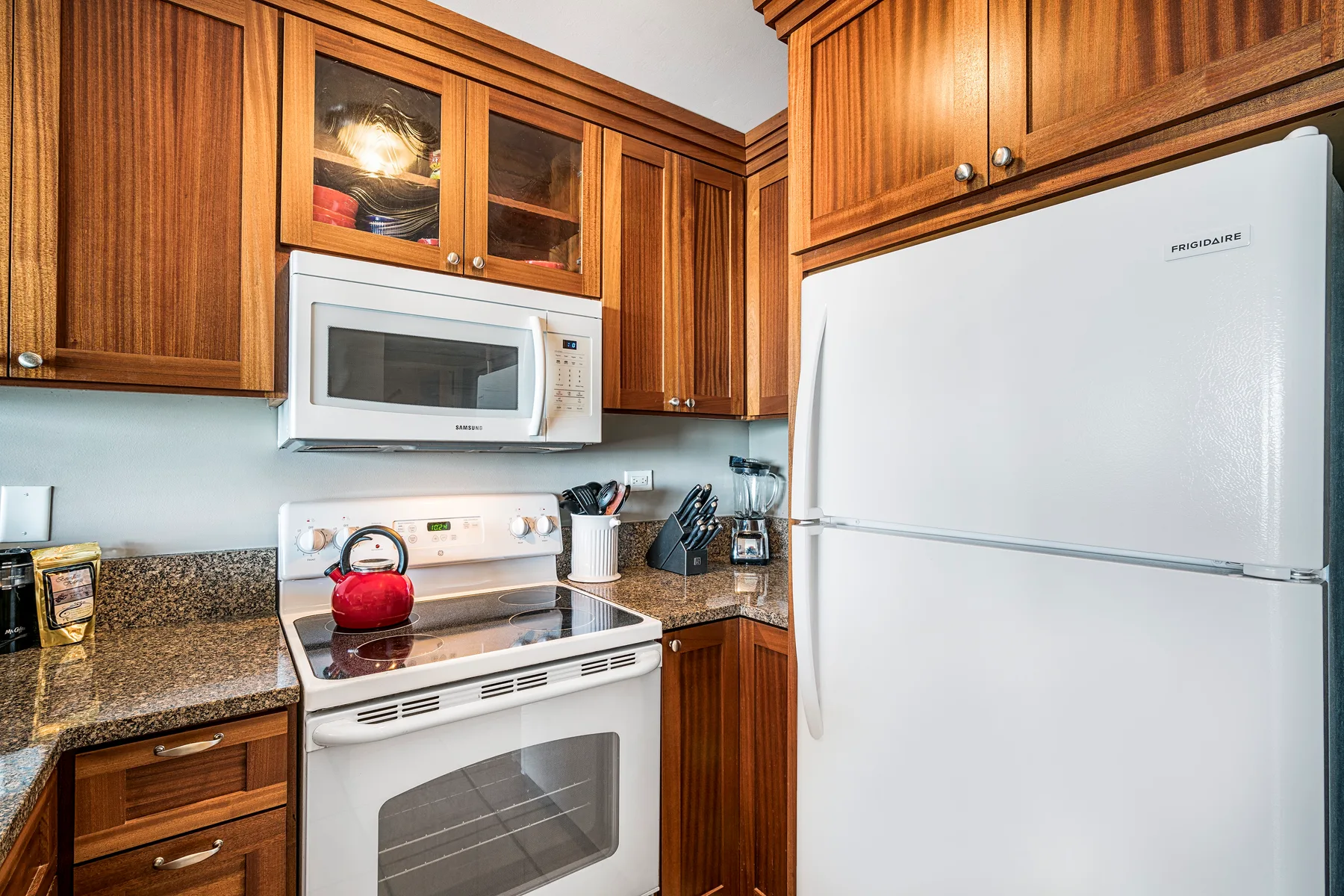 Una cocina con gabinetes de madera, un refrigerador y una estufa.
