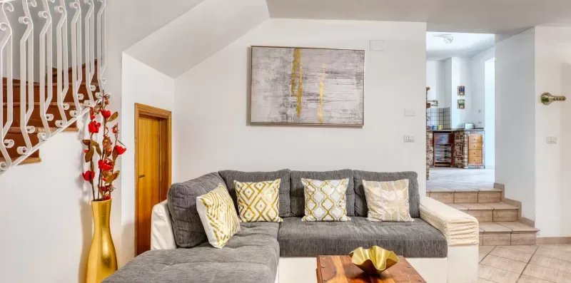 A bright living room features an L-shaped seating area and framed wall art.