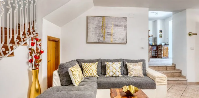 A living room with a gray sectional sofa and framed wall art.