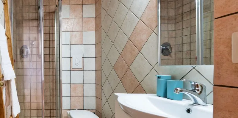 A tiled bathroom with a shower, toilet, and sink.